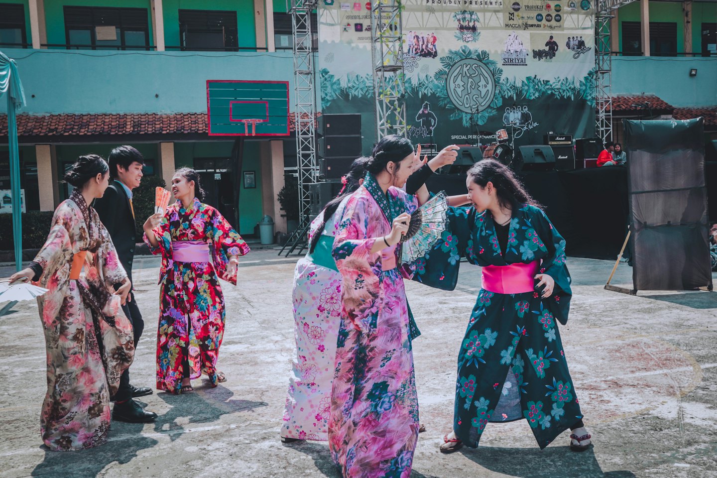 Mensen in kimono's en een pak verzamelen zich voor een evenementenachtergrond.